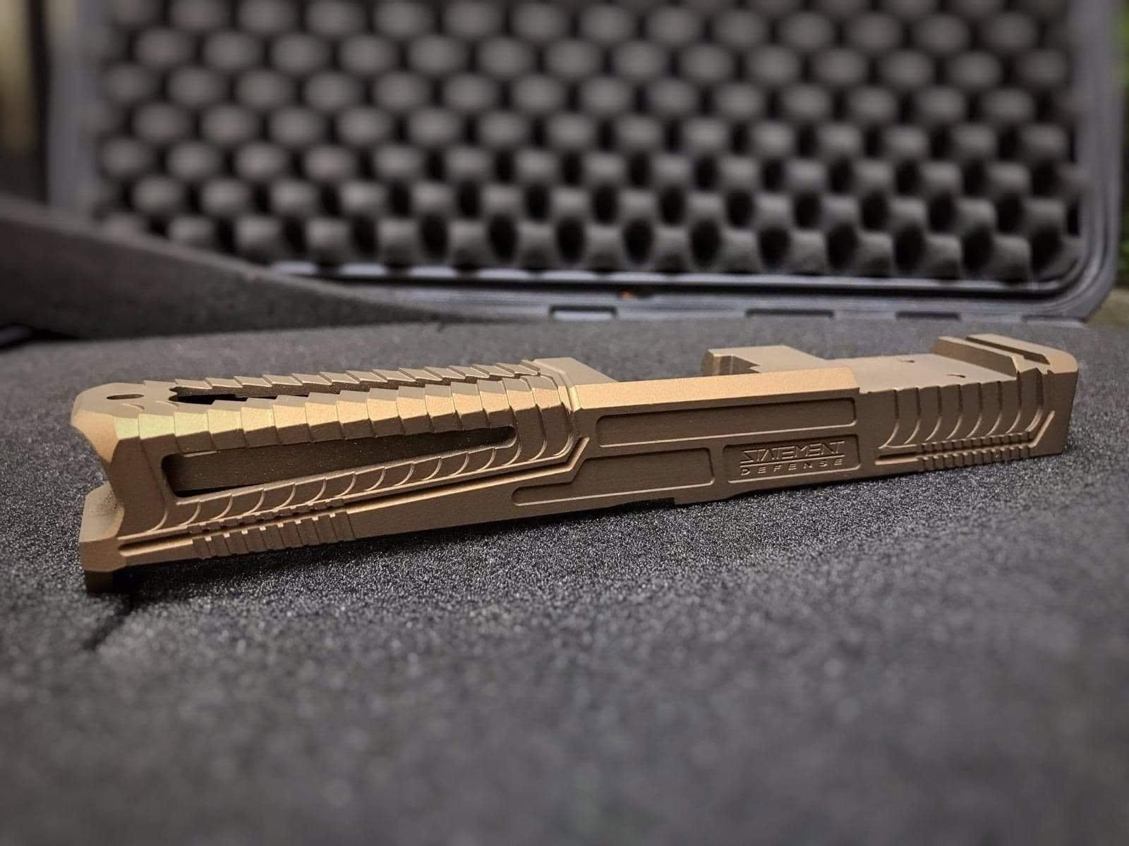 Bronze-finished sporting pistol slide in a protective case