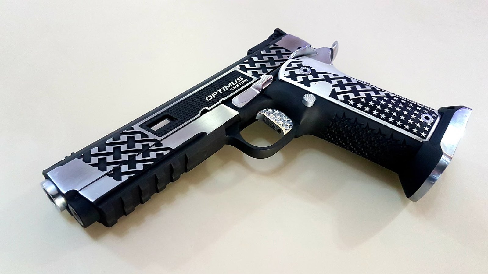Black and silver custom sporting pistol displayed on a light background